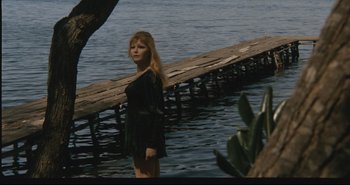 Movie still from “A Bay of Blood” (1971), directed by Mario Bava – A woman standing in the middle of a body of water; Wide shot, High angle