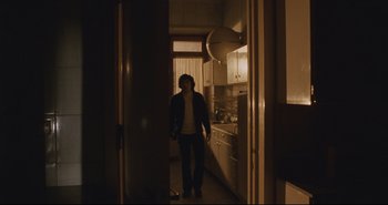 Movie still from “A Bay of Blood” (1971), directed by Mario Bava – A woman standing in a kitchen in the dark; Wide shot, Low angle