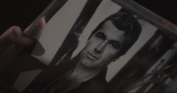 Movie still from “A Bay of Blood” (1971), directed by Mario Bava – An old photo of a man in a black shirt; Extreme Close Up shot, High angle