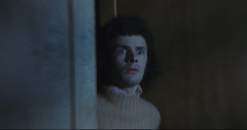 Movie still from “A Bay of Blood” (1971), directed by Mario Bava – A man in a white sweater looking at the camera; Close Up shot, Low angle