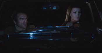 Movie still from “A Bay of Blood” (1971), directed by Mario Bava – A man and a woman sitting in a car at night; Medium shot, Low angle