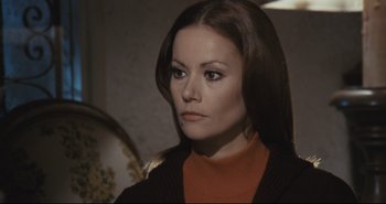 Movie still from “A Bay of Blood” (1971), directed by Mario Bava – A woman with long brown hair wearing an orange sweater; Close Up shot, High angle