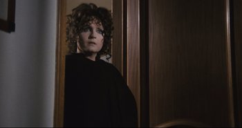 Movie still from “A Bay of Blood” (1971), directed by Mario Bava – A woman with curly hair standing in front of a mirror; Close Up shot, Over the shoulder angle