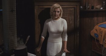 Movie still from “A Bay of Blood” (1971), directed by Mario Bava – A woman standing in front of a wooden cabinet; Medium shot, Low angle