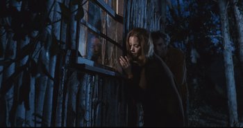 Movie still from “A Bay of Blood” (1971), directed by Mario Bava – A woman standing in front of a window with her eyes closed; Medium shot, Low angle