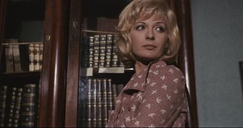 Movie still from “A Bay of Blood” (1971), directed by Mario Bava – A woman standing in front of a book shelf; Close Up shot, Low angle