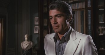 Movie still from “A Bay of Blood” (1971), directed by Mario Bava – A person wearing a suit and tie; Medium shot, Over the shoulder angle
