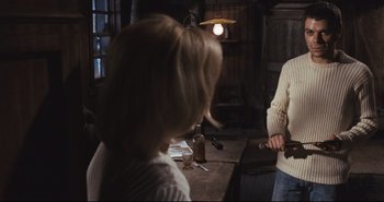 Movie still from “A Bay of Blood” (1971), directed by Mario Bava – Two people are standing in front of a table; Medium shot, Over the shoulder angle