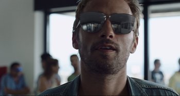 Movie still from “A Bigger Splash” (2015), directed by Luca Guadagnino – A person wearing a pair of sunglasses; Close Up shot, Low angle