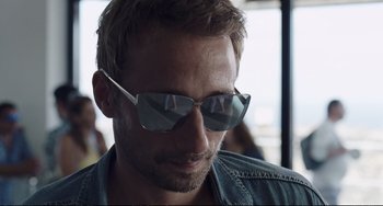 Movie still from “A Bigger Splash” (2015), directed by Luca Guadagnino – A person wearing sunglasses; Close Up shot, Low angle