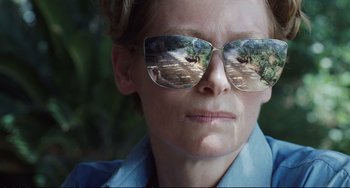 Movie still from “A Bigger Splash” (2015), directed by Luca Guadagnino – A woman wearing a blue shirt and a pair of sunglasses; Close Up shot, Low angle
