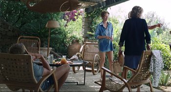 Movie still from “A Bigger Splash” (2015), directed by Luca Guadagnino – A group of people sitting around a patio; Wide shot, Over the shoulder angle