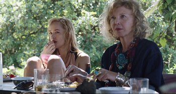 Movie still from “A Bigger Splash” (2015), directed by Luca Guadagnino – Two women are sitting at a table and one is eating; Close Up shot, Over the shoulder angle