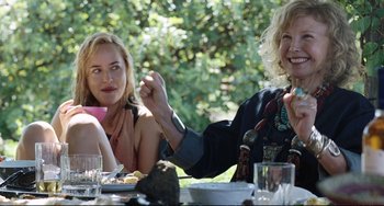 Movie still from “A Bigger Splash” (2015), directed by Luca Guadagnino – Two women are sitting at a table eating; Medium shot, Over the shoulder angle