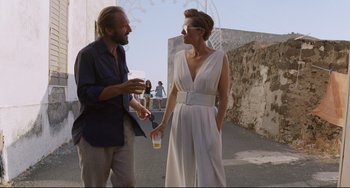 Movie still from “A Bigger Splash” (2015), directed by Luca Guadagnino – A man and a woman standing next to each other on the street; Medium shot, Over the shoulder angle