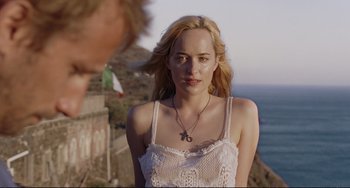 Movie still from “A Bigger Splash” (2015), directed by Luca Guadagnino – A woman in a white dress standing next to a man; Close Up shot, Over the shoulder angle