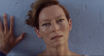 Movie still from “A Bigger Splash” (2015), directed by Luca Guadagnino – A person's face on a blue wall; Close Up shot, Overhead angle