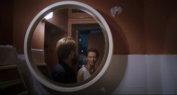 Movie still from “A Bigger Splash” (2015), directed by Luca Guadagnino – A man and a woman are looking in a mirror; Close Up shot, Over the shoulder angle