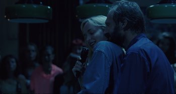 Movie still from “A Bigger Splash” (2015), directed by Luca Guadagnino – A man and a woman sing together in a dark room; Close Up shot, Over the shoulder angle