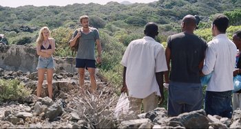 Movie still from “A Bigger Splash” (2015), directed by Luca Guadagnino – A group of people standing on top of a rocky hill; Wide shot, Over the shoulder angle