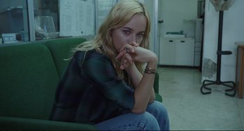 Movie still from “A Bigger Splash” (2015), directed by Luca Guadagnino – A woman sitting on a green chair with her hands on her chin; Medium shot, High angle