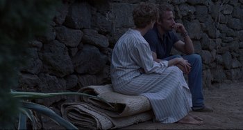 Movie still from “A Bigger Splash” (2015), directed by Luca Guadagnino – A man and a woman sitting next to each other; Wide shot, Over the shoulder angle