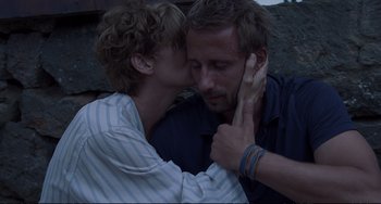 Movie still from “A Bigger Splash” (2015), directed by Luca Guadagnino – A man and a woman kissing each other; Close Up shot, Over the shoulder angle