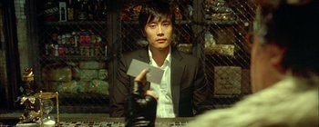 A man sitting at a table holding a business card