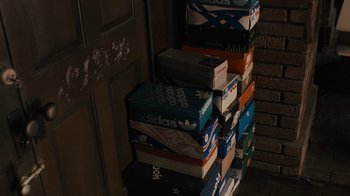 Movie still from “Snowfall” (2017), directed by Hiro Murai – A stack of adidas shoes in front of a door; Extreme Close Up shot, High angle
