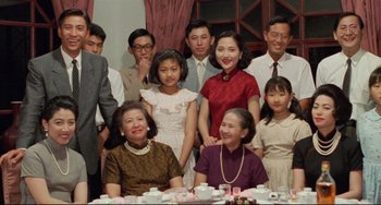 Movie still from “A Brighter Summer Day” (1991), directed by Edward Yang – A group of people posing for a picture at a dinner table; Medium shot, High angle