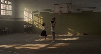 Movie still from “A Brighter Summer Day” (1991), directed by Edward Yang – Two young children playing basketball in an indoor court; Wide shot, Low angle