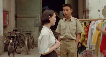 Movie still from “A Brighter Summer Day” (1991), directed by Edward Yang – A man and a woman standing next to each other; Medium shot, Over the shoulder angle