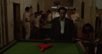 Movie still from “A Brighter Summer Day” (1991), directed by Edward Yang – A group of people playing a game of billiards; Medium shot, High angle