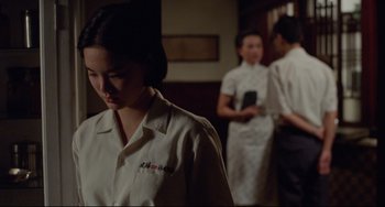 Movie still from “A Brighter Summer Day” (1991), directed by Edward Yang – A woman standing in front of two other people; Medium shot, Over the shoulder angle