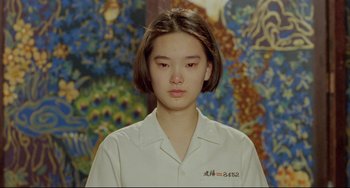 Movie still from “A Brighter Summer Day” (1991), directed by Edward Yang – A young woman with short hair wearing a white shirt; Close Up shot, High angle