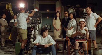 Movie still from “A Brighter Summer Day” (1991), directed by Edward Yang – A group of people standing in a room with a camera; Wide shot, High angle