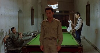 Movie still from “A Brighter Summer Day” (1991), directed by Edward Yang – A man standing in front of a pool table; Medium shot, High angle