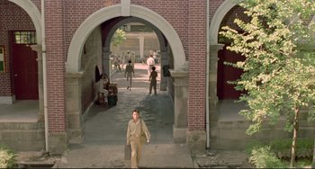 Movie still from “A Brighter Summer Day” (1991), directed by Edward Yang – A man walking down a sidewalk with a briefcase in his hand; Extreme Wide shot, High angle