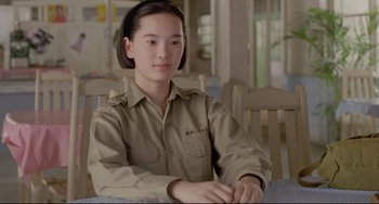 Movie still from “A Brighter Summer Day” (1991), directed by Edward Yang – A woman sitting at a table wearing a uniform; Close Up shot, Over the shoulder angle