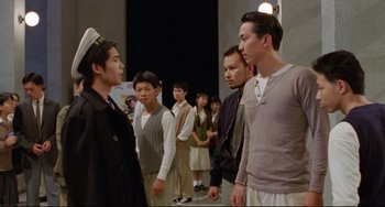 Movie still from “A Brighter Summer Day” (1991), directed by Edward Yang – A group of men standing next to each other in a room; Medium shot, Over the shoulder angle