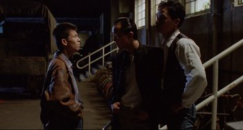 Movie still from “A Brighter Summer Day” (1991), directed by Edward Yang – A group of men standing next to each other in a building; Medium shot, Over the shoulder angle