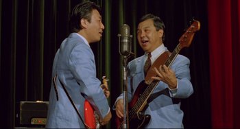 Movie still from “A Brighter Summer Day” (1991), directed by Edward Yang – A couple of men in suits playing instruments; Medium shot, High angle
