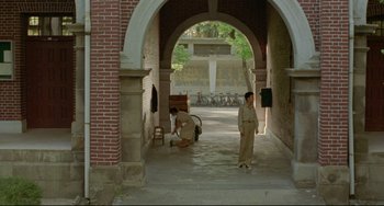 Movie still from “A Brighter Summer Day” (1991), directed by Edward Yang – Two men are standing under an archway in an archway; Extreme Wide shot, High angle