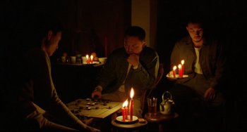 Movie still from “A Brighter Summer Day” (1991), directed by Edward Yang – A group of people sitting around a table with candles; Medium shot, High angle