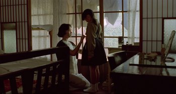Movie still from “A Brighter Summer Day” (1991), directed by Edward Yang – A woman is helping another woman put on a bracelet; Medium shot, Over the shoulder angle