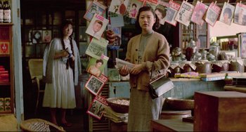 Movie still from “A Brighter Summer Day” (1991), directed by Edward Yang – A woman standing in front of a bunch of magazines; Medium shot, Over the shoulder angle