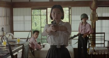 Movie still from “A Brighter Summer Day” (1991), directed by Edward Yang – A woman holding a gun while standing in a room; Medium shot, Low angle