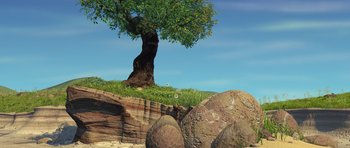 Movie still from “A Bug's Life” (1998), directed by John Lasseter – A tree sitting on top of a hill next to rocks; Extreme Wide shot, High angle
