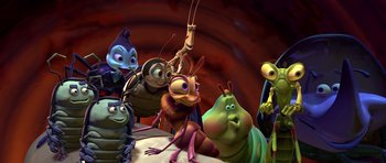 Movie still from “A Bug's Life” (1998), directed by John Lasseter – A group of cartoon bugs sitting on top of a pile of rocks; Wide shot, High angle