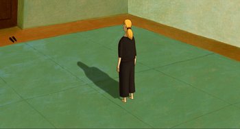 Movie still from “A Cat in Paris” (2010), directed by Alain Gagnol – A person standing in a room with a shadow on the wall; Extreme Wide shot, High angle